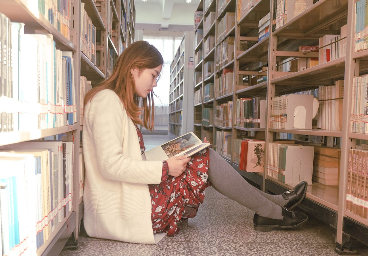 A woman reading a book in a library